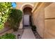 Front entry with arched walkway, mature shrubs, and light-colored door at 16831 S 14Th Ln, Phoenix, AZ 85045