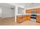 Modern kitchen with wood cabinets and stainless steel appliances at 19234 W Woodlands Ave, Buckeye, AZ 85326