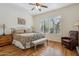 Main bedroom with wood floors, a ceiling fan, and a sitting area at 19550 N Grayhawk Dr # 1136, Scottsdale, AZ 85255