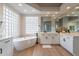 Elegant bathroom with soaking tub, double vanity, and large glass block window at 19608 N Regents Park Dr, Surprise, AZ 85387