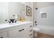 Modern bathroom with white vanity, bathtub, and decorative mirror at 19608 N Regents Park Dr, Surprise, AZ 85387