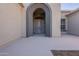 Elegant entryway with arched doorway and security screen door at 19608 N Regents Park Dr, Surprise, AZ 85387