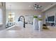 Kitchen island with sink, modern faucet, and decorative vases at 19608 N Regents Park Dr, Surprise, AZ 85387