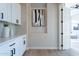 Bright laundry room with white cabinets and built-in shelves at 19608 N Regents Park Dr, Surprise, AZ 85387