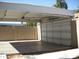 Carport with a white metal roof and a white roll-up door at 2138 W Beaubien Dr, Phoenix, AZ 85027