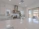 Modern kitchen with white cabinets, large island, and stainless steel appliances at 22413 N 101St Ave, Peoria, AZ 85383