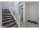 Gray carpeted staircase with white railing and tiled floor at 22413 N 101St Ave, Peoria, AZ 85383