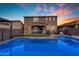 Blue-lit pool at sunset with a large backyard and patio furniture at 2346 S Banning St, Gilbert, AZ 85295