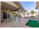 Spacious backyard with covered patio, putting green, and colorful seating at 26602 S Nicklaus Dr, Sun Lakes, AZ 85248