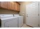 Laundry room with washer, dryer, and overhead cabinets at 27060 W Ross Ave, Buckeye, AZ 85396