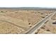 Aerial view of vacant land near a paved road and distant mountains at 2707 S 357Th Dr, Tonopah, AZ 85354