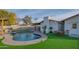 Stunning kidney shaped pool with a pergola, lush lawn, and patio furniture at 3402 E Sunnyside Dr, Phoenix, AZ 85028