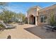 Inviting front patio with seating area, lush landscaping, and a beautiful arched entryway at 34157 N Mirage Ct, San Tan Valley, AZ 85144