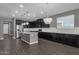 Modern kitchen with dark cabinets, island, and chandelier lighting at 3432 E Alfalfa Dr, Gilbert, AZ 85298