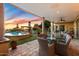 Inviting pool area with covered patio, dining set, and sunset views at 37018 N Tree Lined Trl, Carefree, AZ 85377