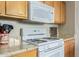 White GE microwave and stovetop with granite countertops at 40901 N Courage Trl, Anthem, AZ 85086