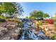 Serene waterfall feature with lush landscaping at 40901 N Courage Trl, Anthem, AZ 85086