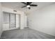 Bedroom with ceiling fan, built-in shelving, and gray carpet at 4250 E Towne Ln, Gilbert, AZ 85234