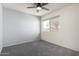 Bedroom with ceiling fan, gray carpet, and large window at 4250 E Towne Ln, Gilbert, AZ 85234