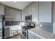 Kitchen featuring gray cabinets, stainless appliances, gray subway tile, and quartz countertops at 4354 N 27Th Pl, Phoenix, AZ 85016