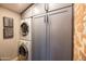 Stackable washer and dryer in a well-lit laundry room with gray cabinets at 45 E Woodward Dr, Phoenix, AZ 85004