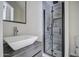 Modern bathroom with gray tile, a white sink, and a glass shower at 6145 W Pierce St, Phoenix, AZ 85043