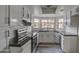 Modern kitchen with white cabinets, black countertops, and a window at 6145 W Pierce St, Phoenix, AZ 85043