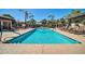 Resort-style pool area with lounge chairs, shaded seating, and mature palm trees at 7009 E Acoma Dr # 1004, Scottsdale, AZ 85254