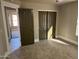 Well-lit bedroom featuring carpet and double doors at 7146 W Emile Zola Ave, Peoria, AZ 85381