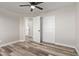 Bedroom with ceiling fan, wood-look floors, and door to hallway at 7602 W Minnezona Ave, Phoenix, AZ 85033