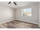 Bright bedroom with ceiling fan, large window, and wood-look floors at 7602 W Minnezona Ave, Phoenix, AZ 85033