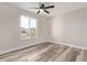 Spacious bedroom with ceiling fan and large window at 7602 W Minnezona Ave, Phoenix, AZ 85033