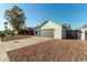 Single-story home with gray garage door and a gravel driveway at 7602 W Minnezona Ave, Phoenix, AZ 85033