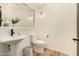 Modern bathroom with a pedestal sink and updated toilet at 8951 E Wethersfield Rd, Scottsdale, AZ 85260