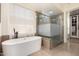 Bathroom featuring a soaking tub, walk-in shower, and separate closet at 8951 E Wethersfield Rd, Scottsdale, AZ 85260