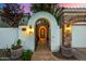 Elegant entryway with arched walkway, wrought iron door, and stone accents at 8951 E Wethersfield Rd, Scottsdale, AZ 85260