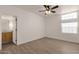 Bright bedroom with wood-look floors, ceiling fan, and ensuite bathroom access at 1245 W 1St St # 103, Tempe, AZ 85281