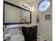 Clean bathroom with dark vanity and a round window at 13842 S 40Th St # 1004, Phoenix, AZ 85044