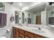 Bathroom with double sinks, wood cabinets, and large mirror at 13872 N 89Th St, Scottsdale, AZ 85260