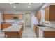 Bright kitchen featuring an island, stainless steel appliances, and wood cabinets at 16370 W Adams St, Goodyear, AZ 85338