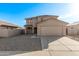 Two-story house with beige exterior, two-car garage, and landscaped front yard at 16765 W Hadley St, Goodyear, AZ 85338