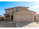 Two-story house with beige exterior, two-car garage, and landscaped front yard at 16765 W Hadley St, Goodyear, AZ 85338