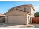 Two-story house with beige exterior, two-car garage, and landscaped front yard at 16765 W Hadley St, Goodyear, AZ 85338