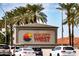 The Sun City West entrance sign stands tall amidst palm trees on a sunny day at 17635 N Buntline Dr, Sun City West, AZ 85375