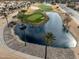 Overhead image of a scenic golf course hole with a sand trap and blue water feature, framed by palm trees at 17635 N Buntline Dr, Sun City West, AZ 85375