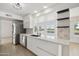 Modern white kitchen with stainless steel appliances and a breakfast bar at 17635 N Buntline Dr, Sun City West, AZ 85375