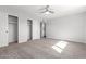 Carpeted bedroom features ceiling fan, closets, and access to ensuite bathroom at 1839 E Indigo St, Mesa, AZ 85203