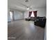 Bright living room featuring gray laminate floors and a comfortable sectional sofa at 1839 E Indigo St, Mesa, AZ 85203