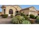 Tan two-story house with a three-car garage and nicely landscaped yard at 20359 N 262Nd Dr, Buckeye, AZ 85396