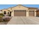 Tan two-story house with a three-car garage and landscaped front yard at 20359 N 262Nd Dr, Buckeye, AZ 85396